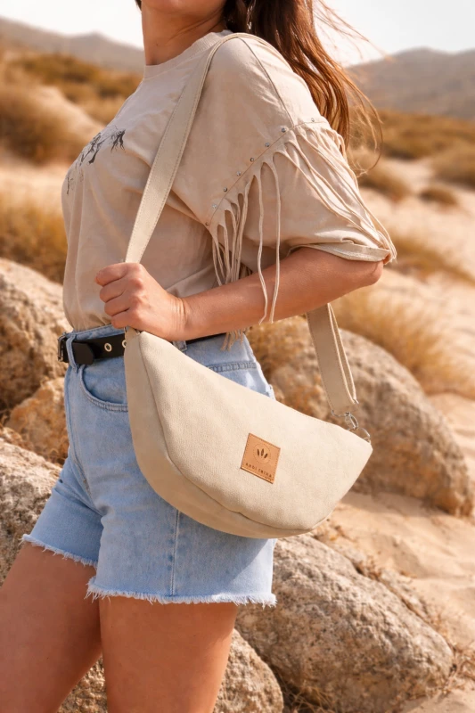 Zamszowa torebka rogalik w beżowym kolorze to stylowy i funkcjonalny dodatek na co dzień – miękka w dotyku, lekka i wygodna, idealna do casualowych i letnich stylizacji, podkreśla naturalną elegancję i ponadczasowy design.