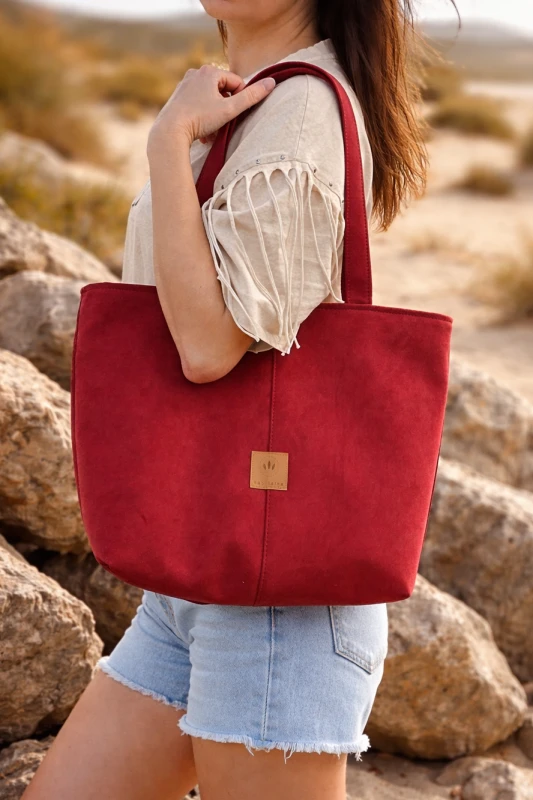 Stylowa zamszowa torba shopper w intensywnym czerwonym kolorze – pojemna, lekka i idealna na co dzień. Miękka faktura, wygodne uchwyty i ponadczasowy design sprawiają, że pasuje do każdej stylizacji.