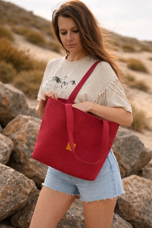 Stylowa zamszowa torba shopper w intensywnym czerwonym kolorze – pojemna, lekka i idealna na co dzień. Miękka faktura, wygodne uchwyty i ponadczasowy design sprawiają, że pasuje do każdej stylizacji.
