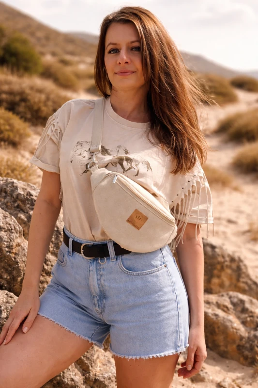 Kremowa zamszowa nerka damska – elegancka, miękka i funkcjonalna. Idealna na co dzień i podróże, łączy styl z wygodą. Regulowany pasek, modny fason i wysokiej jakości materiał podkreślą każdą stylizację.