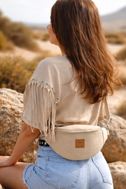 Kremowa zamszowa nerka damska – elegancka, miękka i funkcjonalna. Idealna na co dzień i podróże, łączy styl z wygodą. Regulowany pasek, modny fason i wysokiej jakości materiał podkreślą każdą stylizację.