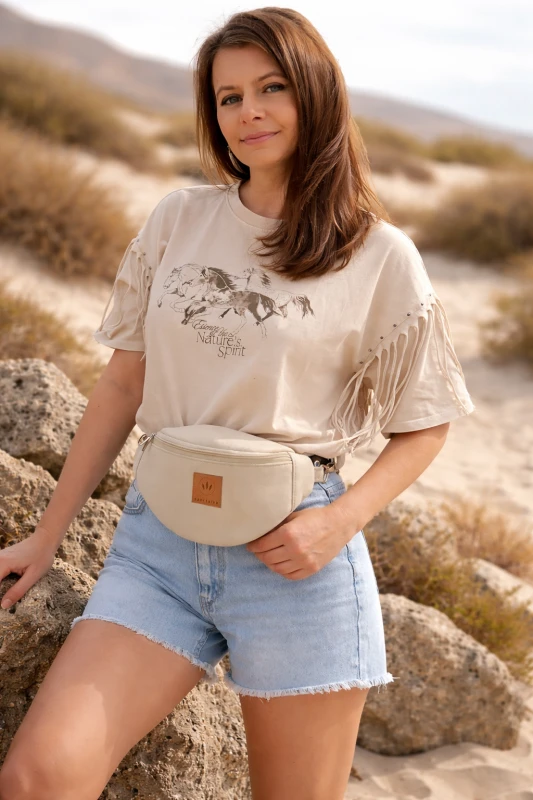 Kremowa zamszowa nerka damska – elegancka, miękka i funkcjonalna. Idealna na co dzień i podróże, łączy styl z wygodą. Regulowany pasek, modny fason i wysokiej jakości materiał podkreślą każdą stylizację.