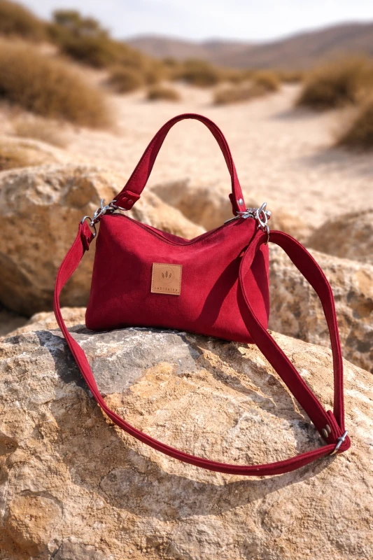 Mała czerwona torebka z zamszu – elegancka i stylowa, idealna na co dzień i wyjątkowe okazje. Miękka faktura, kompaktowy rozmiar i regulowany pasek zapewniają wygodę oraz modny wygląd.