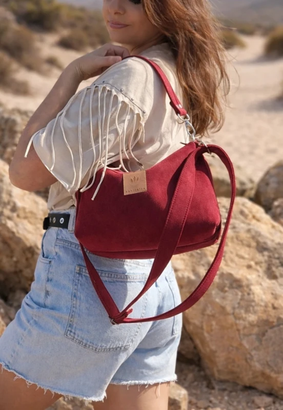 Mała czerwona torebka z zamszu – elegancka i stylowa, idealna na co dzień i wyjątkowe okazje. Miękka faktura, kompaktowy rozmiar i regulowany pasek zapewniają wygodę oraz modny wygląd.