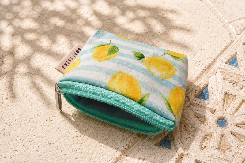 Stylowe etui na karty z motywem cytryn i pastelowych pasków. Lekka, praktyczna saszetka z zamkiem – idealna na karty, monety i drobiazgi. Śródziemnomorski design, wysoka jakość wykonania i letni, świeży styl na co dzień.