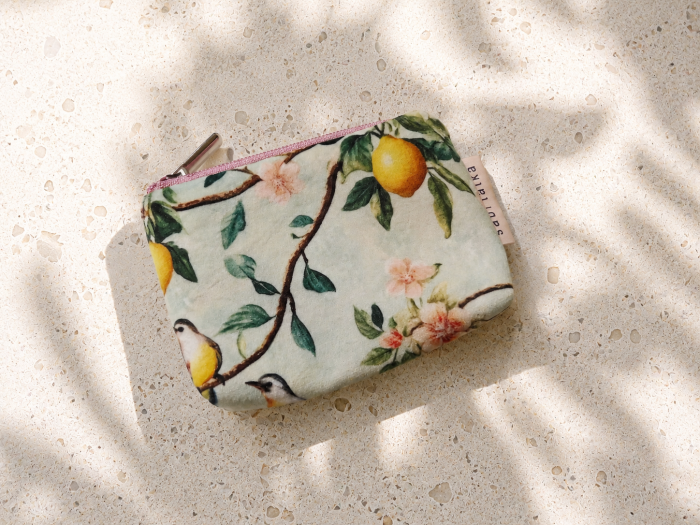 Małe etui na karty i monety w cytrusowo-kwiatowy wzór z pastelowym zamkiem. Lekkie, poręczne i stylowe – idealne do przechowywania kart, gotówki i drobiazgów. Naturalny design inspirowany śródziemnomorskim stylem.