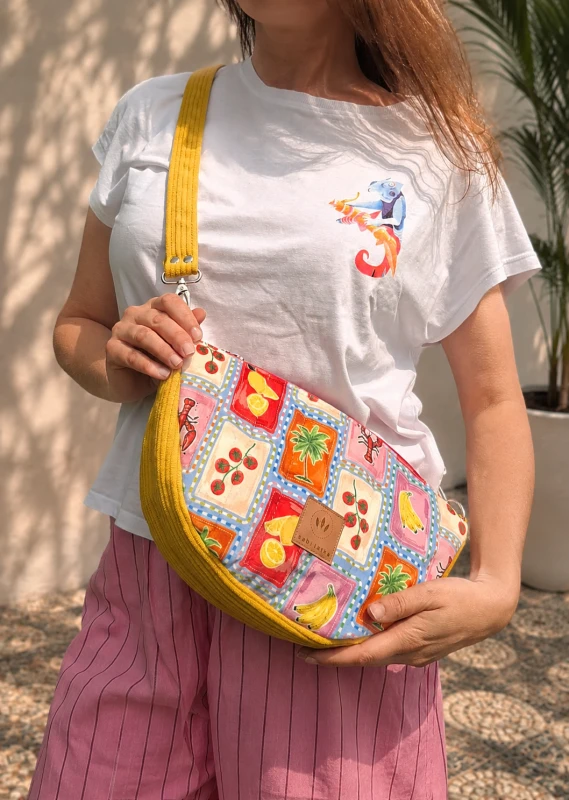 Pikowana torebka crossbody z kolorowym tropikalnym wzorem owoców i palm. Lekka, pojemna i wygodna na co dzień. Regulowany pasek oraz modny design sprawiają, że idealnie uzupełnia letnie i casualowe stylizacje.