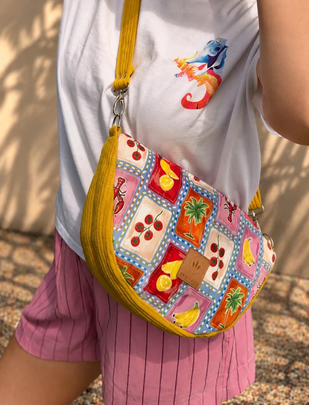 Pikowana torebka crossbody z kolorowym tropikalnym wzorem owoców i palm. Lekka, pojemna i wygodna na co dzień. Regulowany pasek oraz modny design sprawiają, że idealnie uzupełnia letnie i casualowe stylizacje.