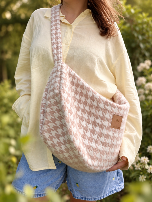 Puchata torba hobo w modną pepitkę w odcieniach pudrowego różu i ecru. Miękka, pojemna i lekka, idealna na co dzień. Szeroki pasek zapewnia wygodę noszenia, a oryginalna faktura nadaje stylizacji wyjątkowy, przytulny charakter.