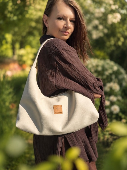 Miękka torebka slouchy z kremowego zamszu zachwyca minimalistycznym designem i pojemnym wnętrzem. Lekka, wygodna i stylowa, idealnie uzupełnia codzienne oraz eleganckie stylizacje. Ponadczasowy fason i najwyższa jakość wykonania.