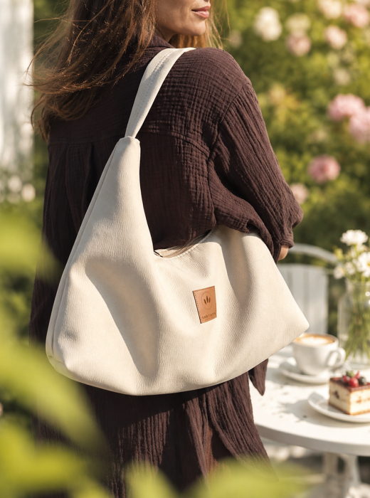 Miękka torebka slouchy z kremowego zamszu zachwyca minimalistycznym designem i pojemnym wnętrzem. Lekka, wygodna i stylowa, idealnie uzupełnia codzienne oraz eleganckie stylizacje. Ponadczasowy fason i najwyższa jakość wykonania.