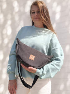 Czekoladowa nerka crossbody z miękkiego zamszu to stylowy dodatek na co dzień. Pojemna, lekka i wygodna, posiada regulowany pasek oraz praktyczne wnętrze. Idealnie uzupełni casualowe i miejskie stylizacje.