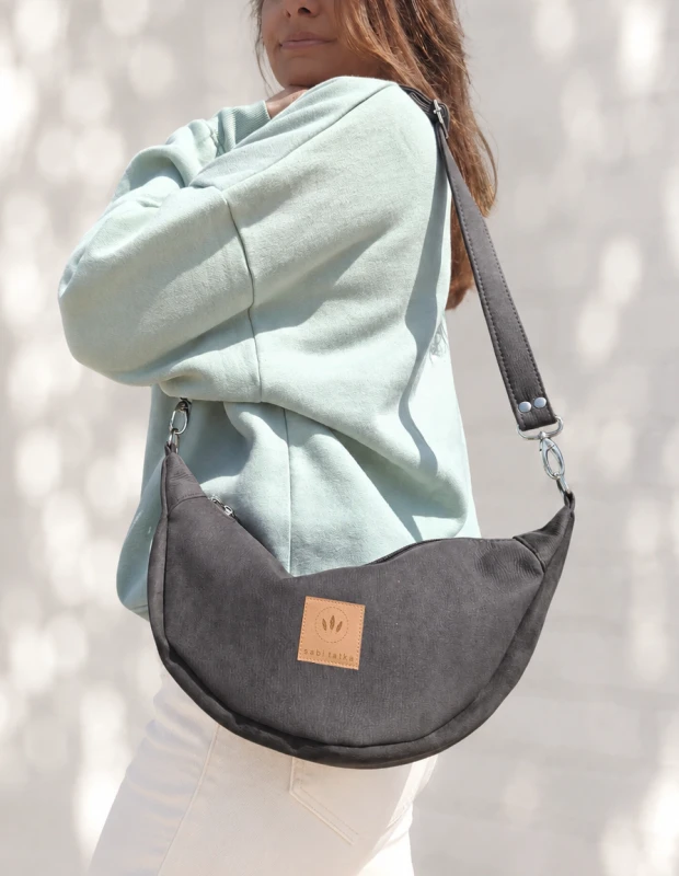 Czekoladowa nerka crossbody z miękkiego zamszu to stylowy dodatek na co dzień. Pojemna, lekka i wygodna, posiada regulowany pasek oraz praktyczne wnętrze. Idealnie uzupełni casualowe i miejskie stylizacje.