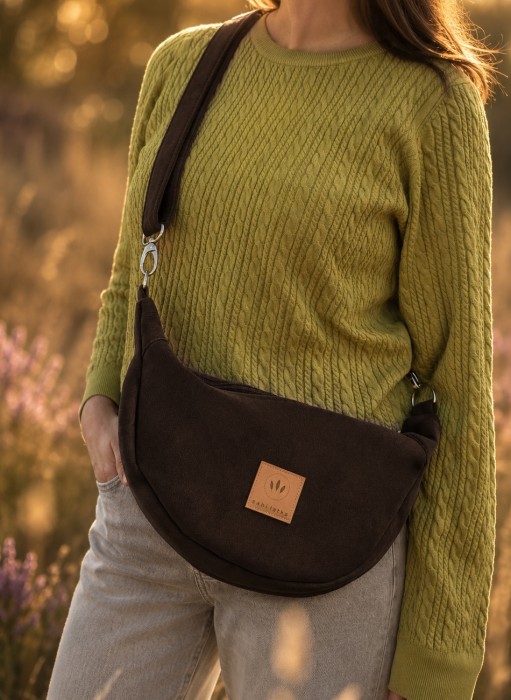 Czekoladowa nerka crossbody z miękkiego zamszu to stylowy dodatek na co dzień. Pojemna, lekka i wygodna, posiada regulowany pasek oraz praktyczne wnętrze. Idealnie uzupełni casualowe i miejskie stylizacje.
