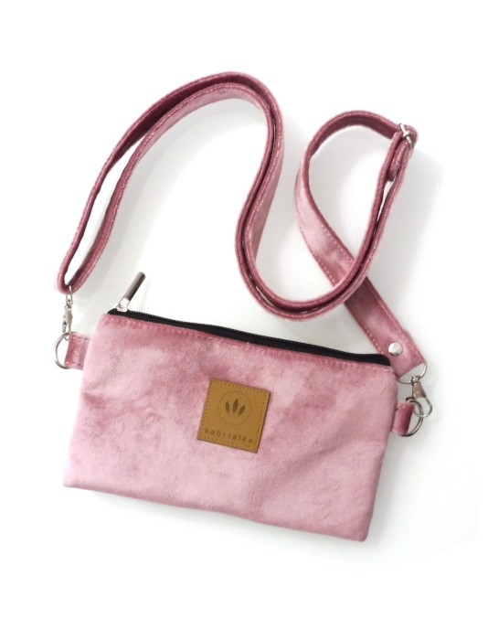 Welurowa saszetka na telefon w kolorze jasnoróżowym, noszona na skos. Miękka faktura, kompaktowy kształt i regulowany pasek czynią ją idealną na spacer, miasto i podróże. Stylowa i praktyczna.